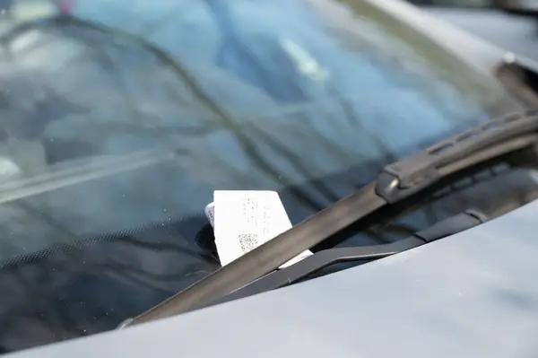 Папірець із QR-кодом під двірником лобового скла автомобіля